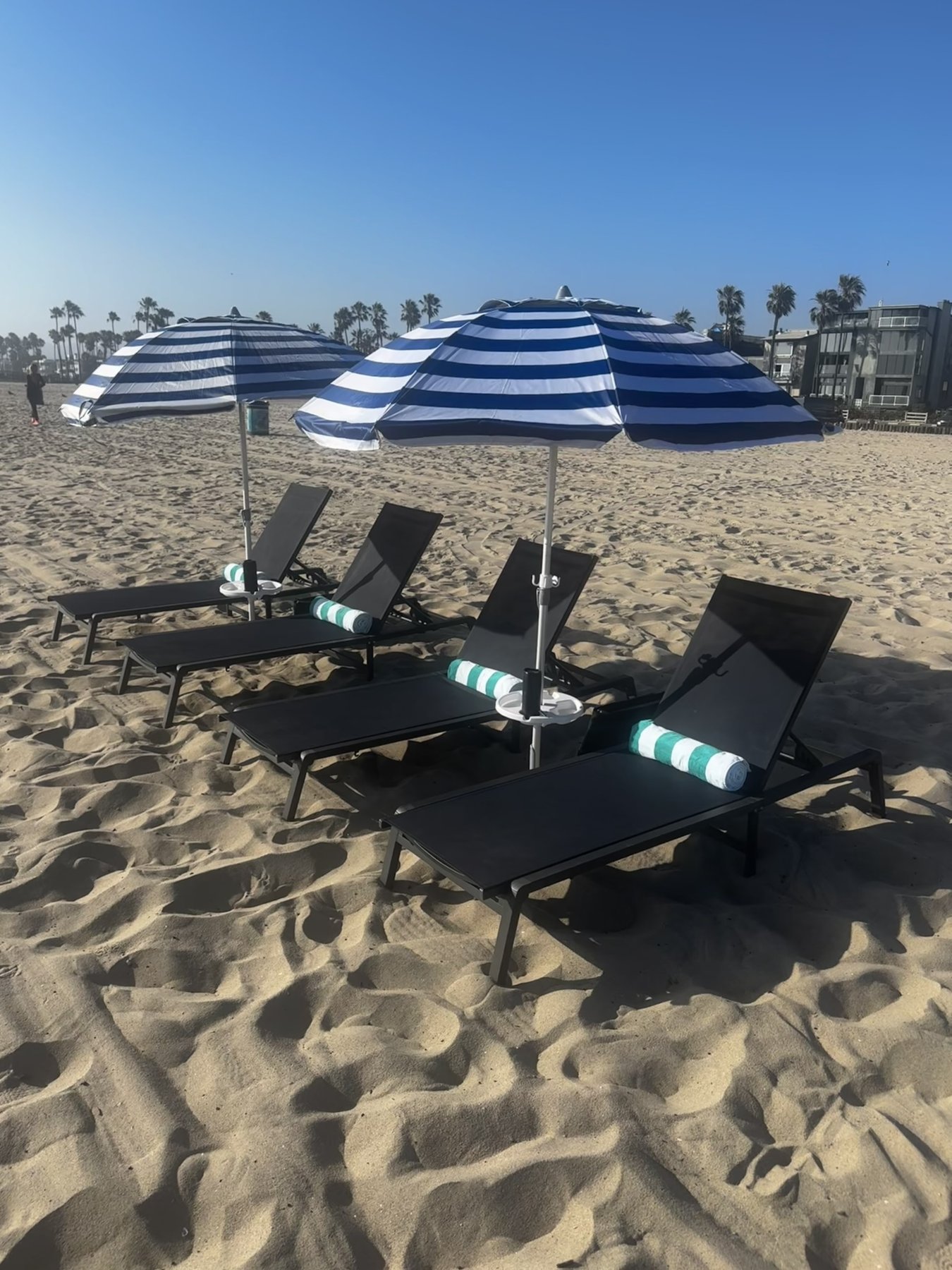 Chairs and striped umbrellas set up on the sand at South Venice